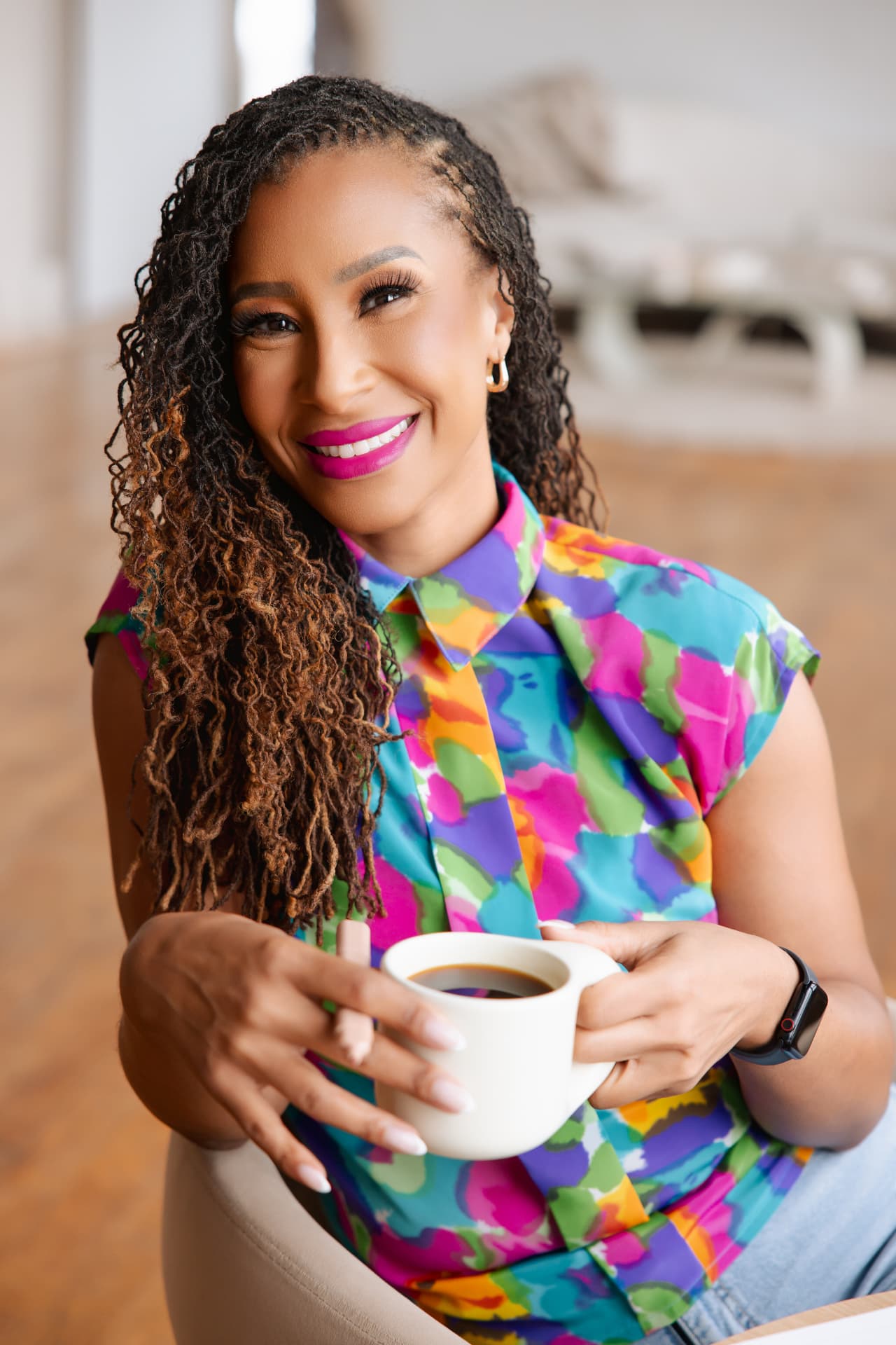 Mikki, founder of Mikki Lists ATL, smiling with a cup of coffee